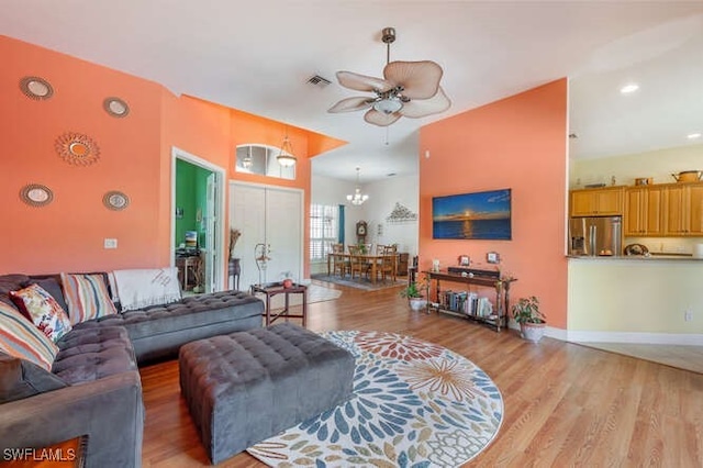 living room featuring lofted ceiling, ceiling fan, and light hardwood / wood-style floors