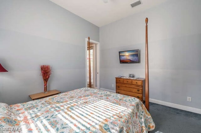 bedroom with vaulted ceiling and dark colored carpet