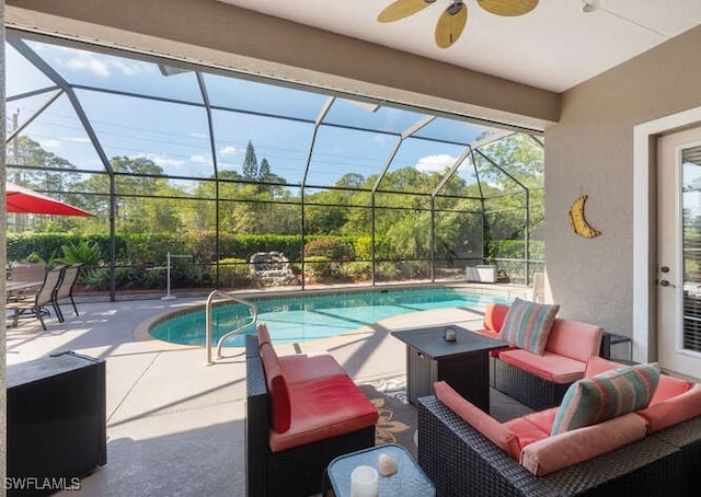 view of pool featuring ceiling fan, a patio, glass enclosure, and an outdoor living space