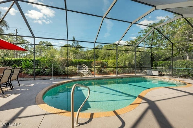 view of swimming pool featuring a lanai and a patio