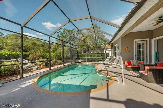 view of swimming pool with ceiling fan, a lanai, an outdoor hangout area, and a patio area