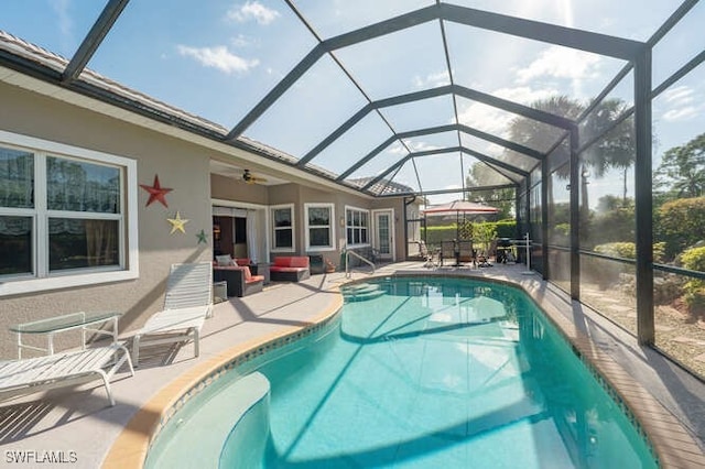 view of swimming pool with ceiling fan, a lanai, a patio, and an outdoor living space