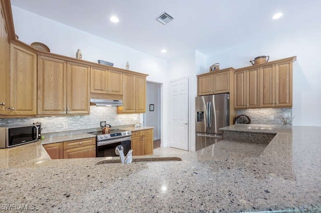 kitchen featuring under cabinet range hood, stainless steel appliances, visible vents, light stone countertops, and tasteful backsplash