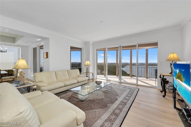 living room featuring ornamental molding, a water view, a notable chandelier, and light hardwood / wood-style flooring