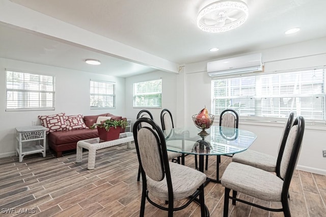 dining room with a wall mounted air conditioner, beam ceiling, and a wealth of natural light