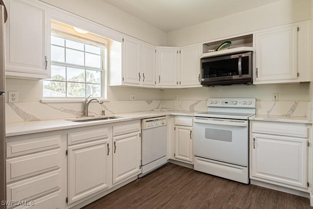 kitchen featuring dark hardwood / wood-style floors, white cabinetry, sink, and white appliances