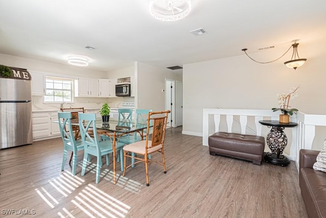 dining room with sink and light hardwood / wood-style flooring