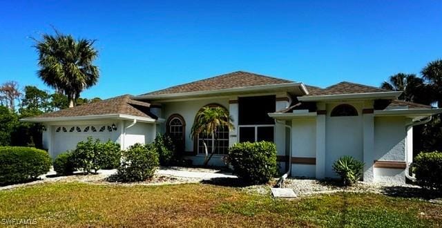 view of front of home with a garage and a front lawn