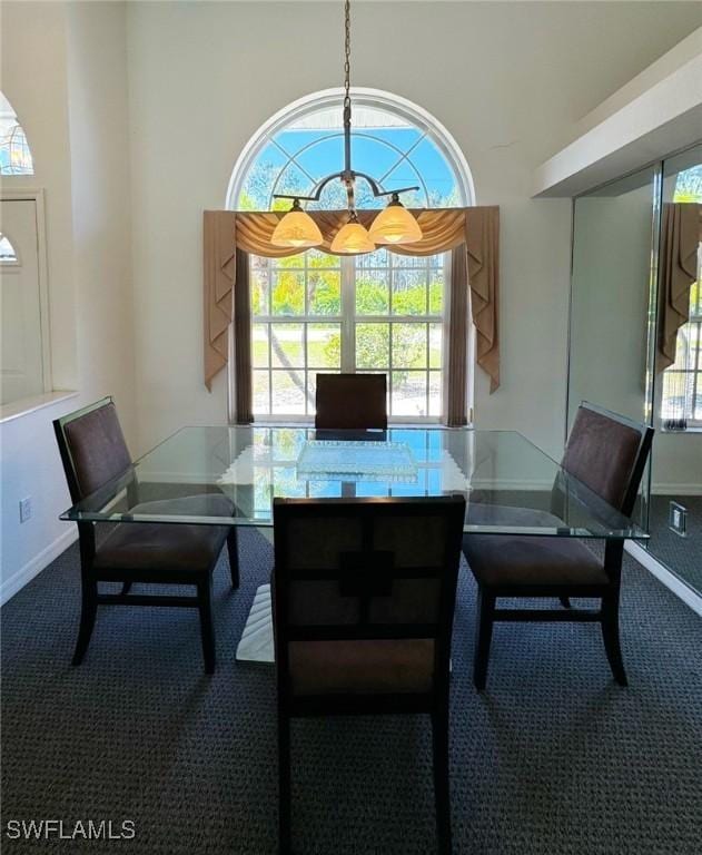 dining room featuring carpet flooring and a high ceiling