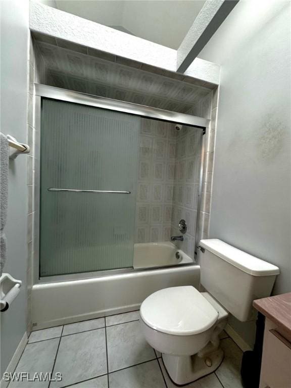 full bathroom with tile patterned floors, combined bath / shower with glass door, toilet, and vanity