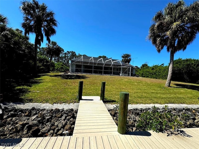 view of dock with glass enclosure and a yard