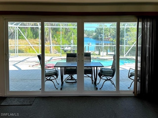 doorway featuring carpet flooring, plenty of natural light, and a water view