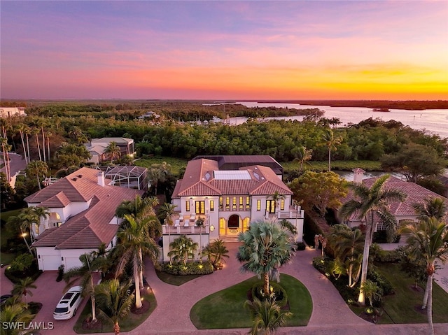 aerial view at dusk featuring a water view