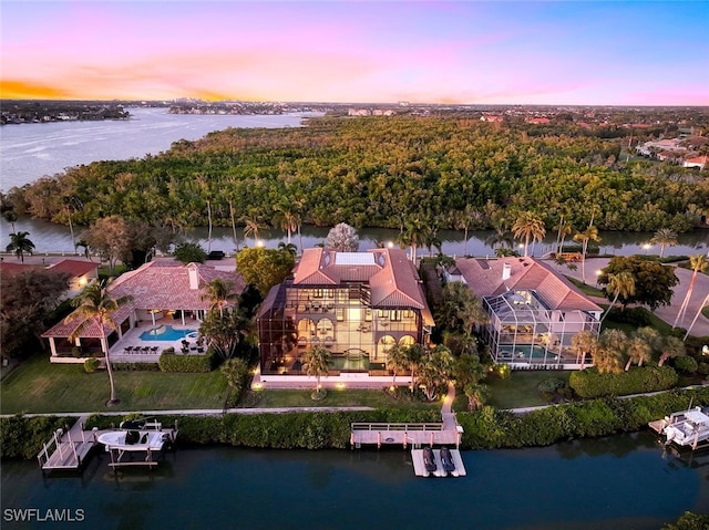 aerial view at dusk featuring a water view