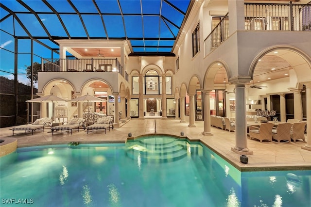 view of swimming pool featuring a lanai, a patio area, and ceiling fan