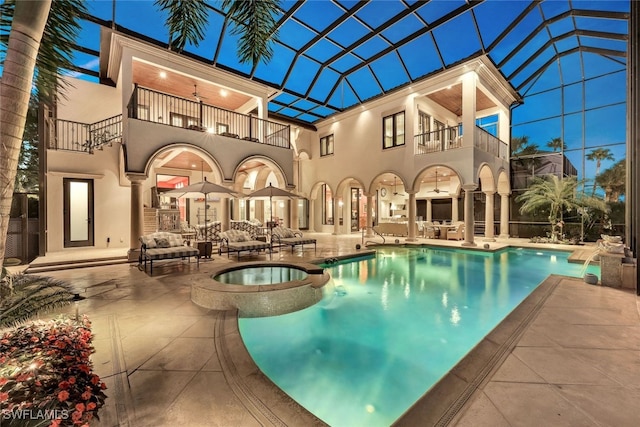 rear view of property with an outdoor living space, pool water feature, a swimming pool with hot tub, a balcony, and a patio