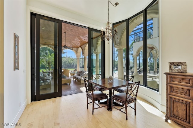 dining space featuring light hardwood / wood-style floors, french doors, and a chandelier