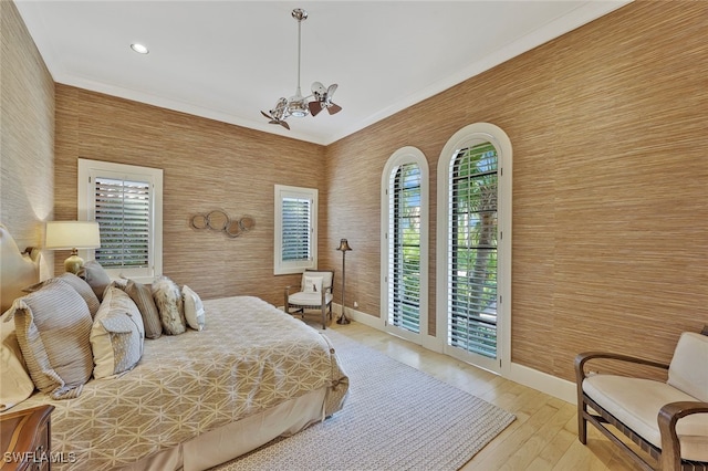 bedroom with access to outside, multiple windows, and a notable chandelier