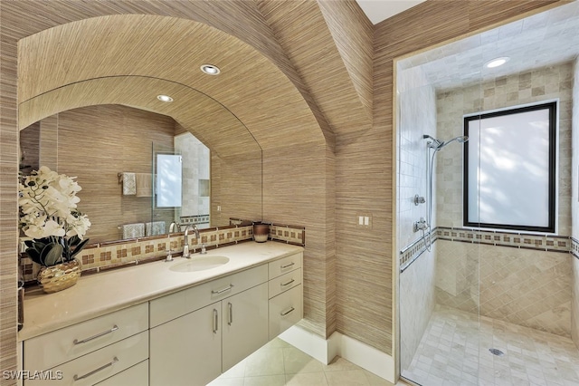 bathroom featuring decorative backsplash, tile patterned floors, an enclosed shower, vanity, and tile walls