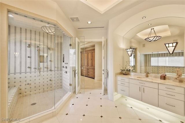 bathroom with vanity, a healthy amount of sunlight, and tiled shower