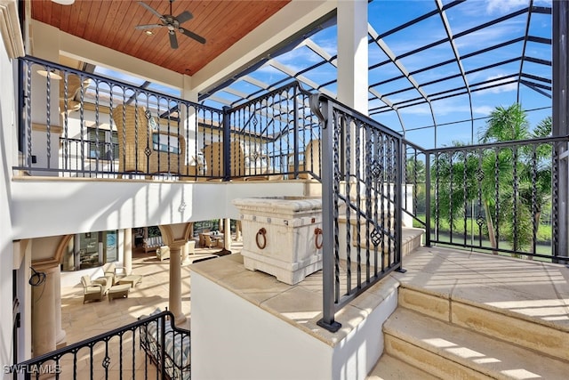 view of patio featuring ceiling fan and glass enclosure