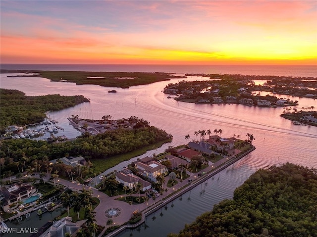 aerial view at dusk featuring a water view