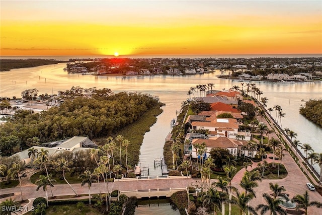 aerial view at dusk featuring a water view