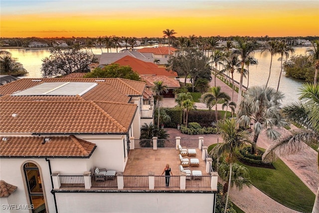 aerial view at dusk featuring a water view