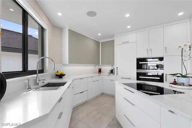 kitchen with light tile patterned floors, sink, white cabinetry, and black appliances