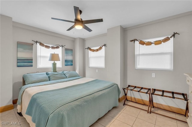 bedroom featuring ceiling fan, baseboards, and light tile patterned flooring