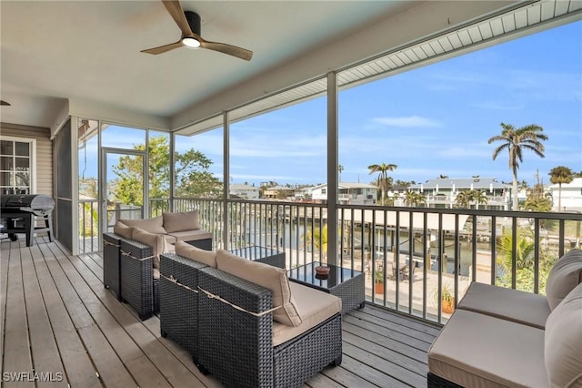 sunroom with a water view and ceiling fan