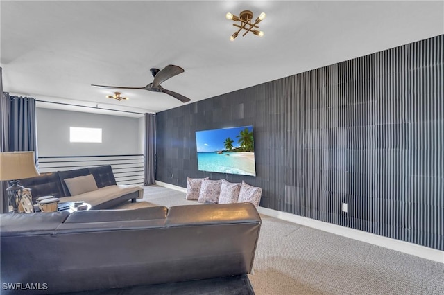 carpeted cinema room with ceiling fan and baseboards