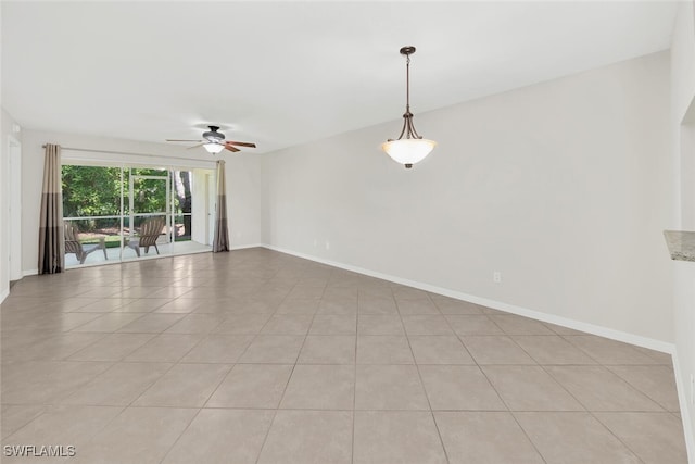 empty room featuring light tile patterned flooring, ceiling fan, and baseboards