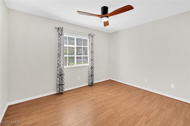 spare room featuring ceiling fan, wood finished floors, and baseboards