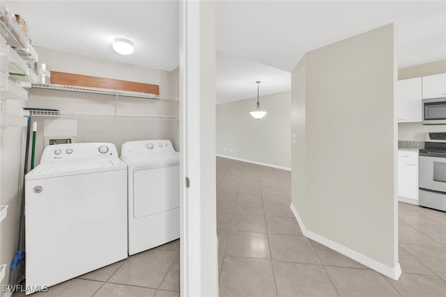 laundry area with laundry area, light tile patterned floors, baseboards, and separate washer and dryer