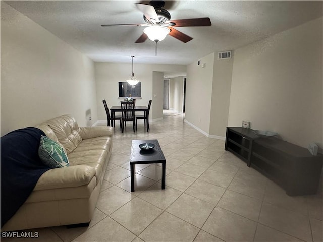 living area featuring visible vents, ceiling fan, baseboards, and light tile patterned floors