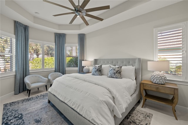 bedroom with a tray ceiling and ceiling fan