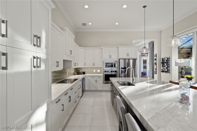 kitchen featuring sink, hanging light fixtures, appliances with stainless steel finishes, light stone countertops, and white cabinets