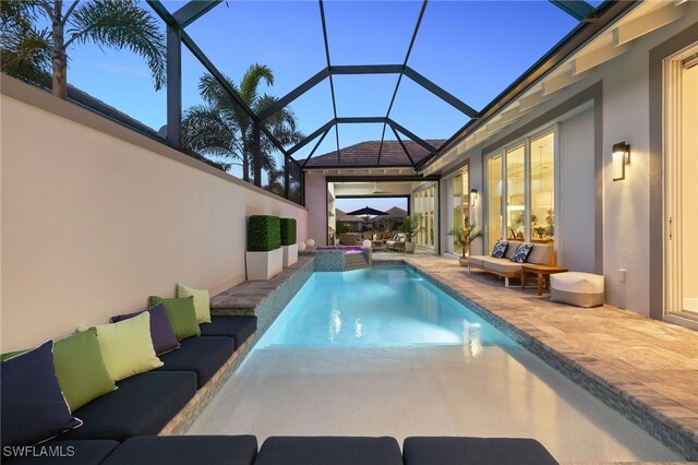 view of swimming pool featuring an outdoor living space, a lanai, and a patio area