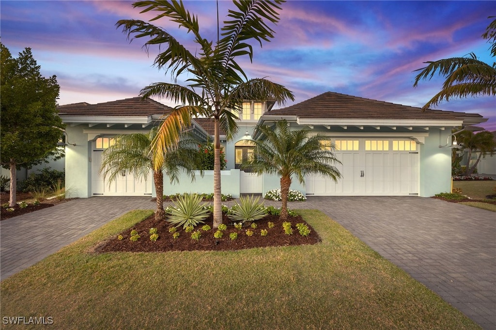 view of front of property featuring a garage and a lawn