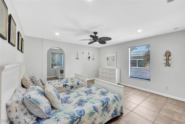 bedroom with multiple windows, light tile patterned floors, and ceiling fan