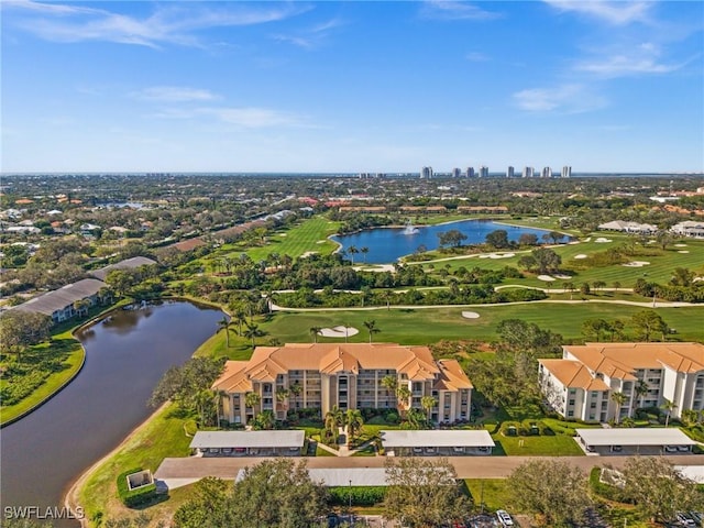 drone / aerial view with a water view and golf course view