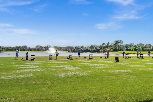 view of home's community with a water view and a lawn