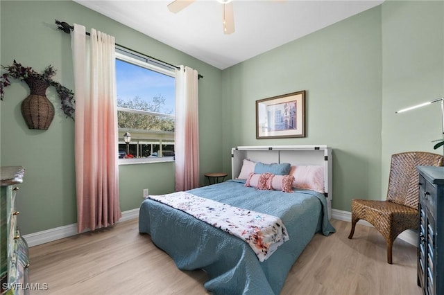 bedroom featuring a ceiling fan, baseboards, and wood finished floors