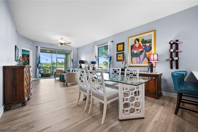 dining space with baseboards, ceiling fan, and light wood finished floors