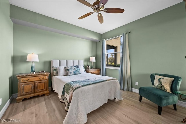 bedroom with ceiling fan, light wood finished floors, and baseboards