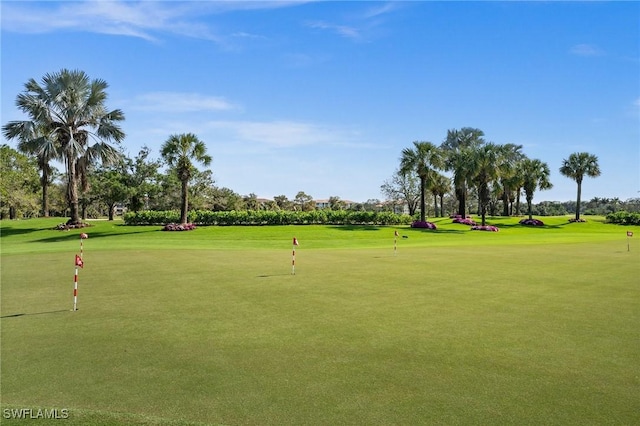 view of home's community with view of golf course and a yard