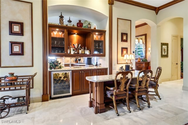 bar with sink, light stone countertops, ornamental molding, and wine cooler