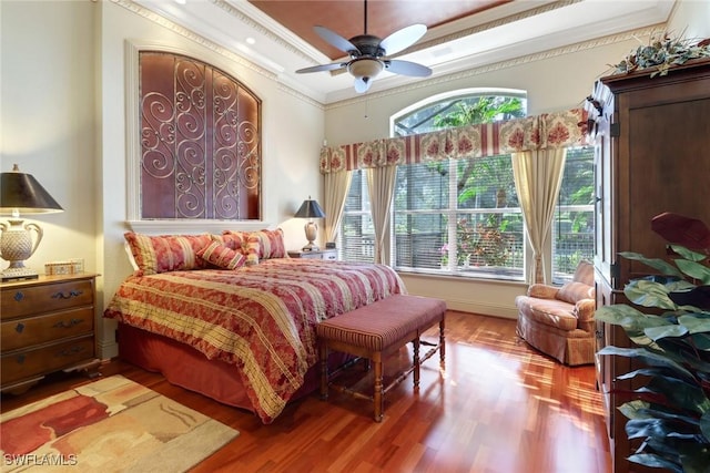 bedroom featuring hardwood / wood-style flooring, ceiling fan, and crown molding