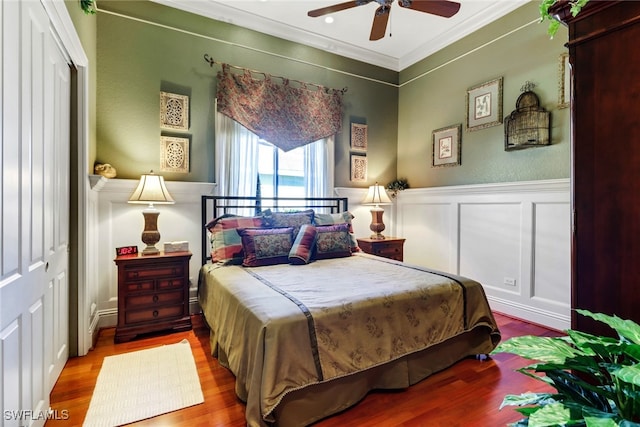 bedroom with wood-type flooring, a closet, ceiling fan, and ornamental molding